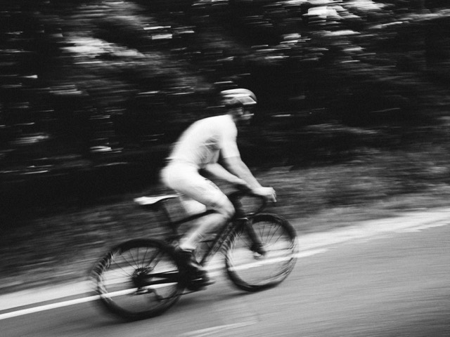 A cyclist in motion rendered in high-contrast black and white