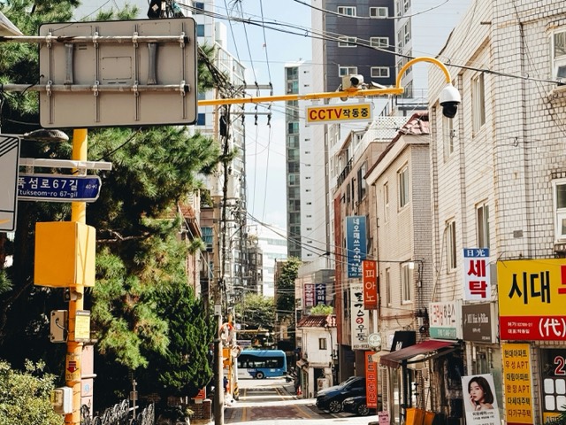 A dense city corner layered with Korean and English signs